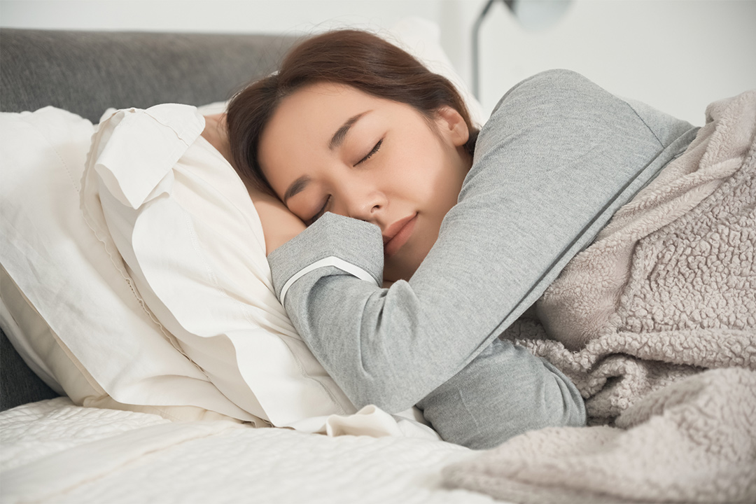 ベッドで睡眠をする女性